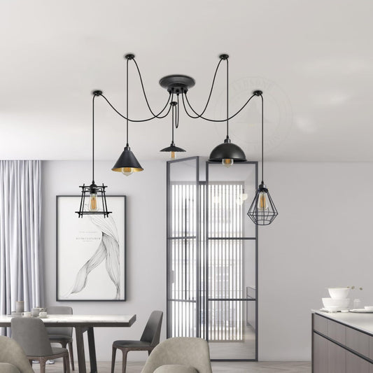 Suspension cage industrielle 5 lumières en métal noir au-dessus d'une table bois.